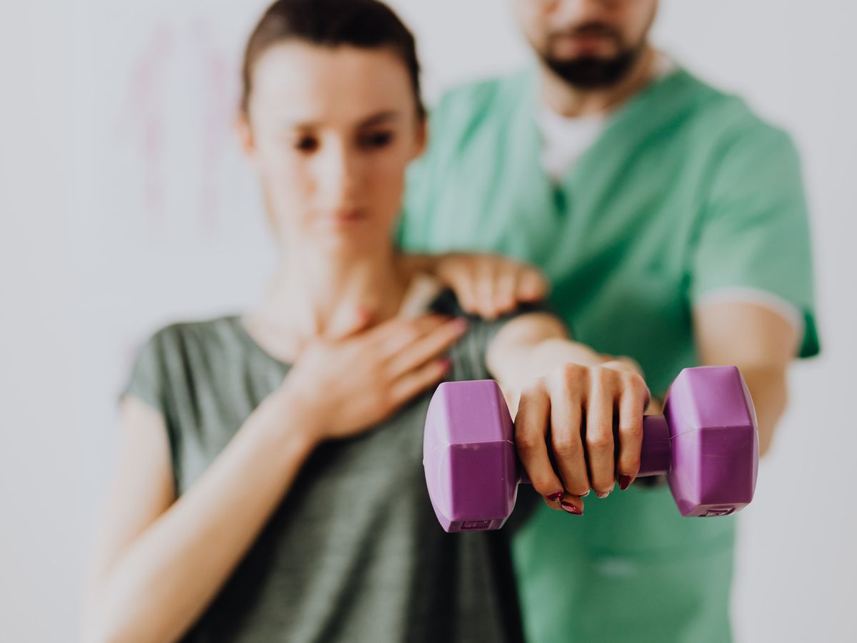 Physician guiding a patient through rehabilitation